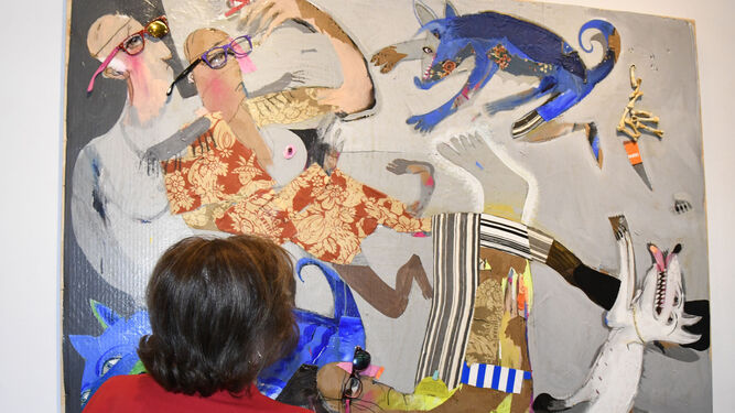 Una mujer observa al detalle uno de los cuadros de la exposición 'Miopes como yo'.