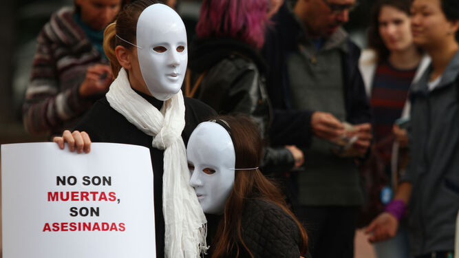 Dos personas enmascaradas el 25-N muestran un cartel reivindicativo sobre la violencia machista.