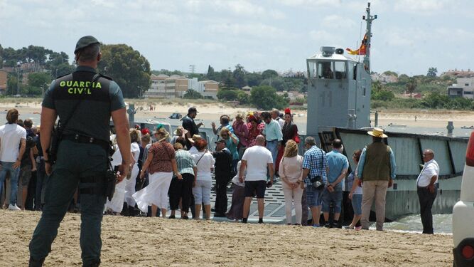 Un agente vigila el desembarco de peregrinos en la Punta de Malandar, ayer.