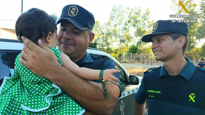 Imagen difundida por la Guardia Civil de los agentes con la pequeña que fue salvada el viernes.