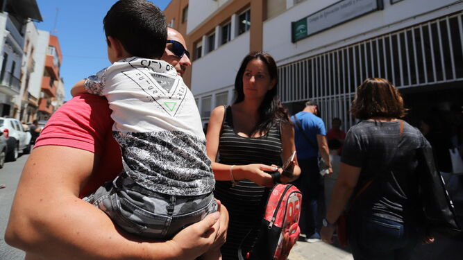 Antonio, con su hijo en brazos, y Rocío a la salida del centro educativo.