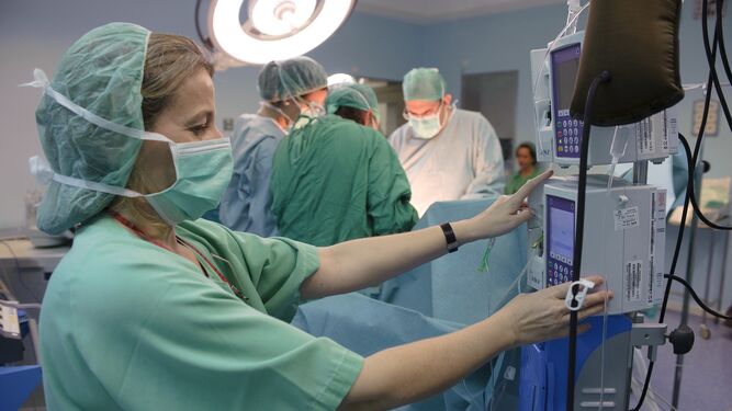 Una enfermera  controla las constantes de un paciente en quirófano.