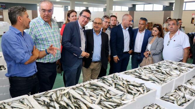 Los responsables de la Junta y del PP con los del sector pesquero en la lonja de Isla Cristina.