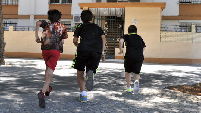 Tres niños jugando en las calles de un barrio andaluz de baja renta.