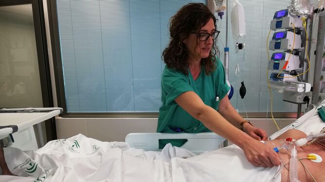 Una enfermera atiende a un paciente en la UCI del Juan Ramón Jiménez.