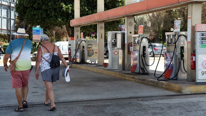 Dos turistas pasan por una gasolinera portuguesa vacía, sin suministro.