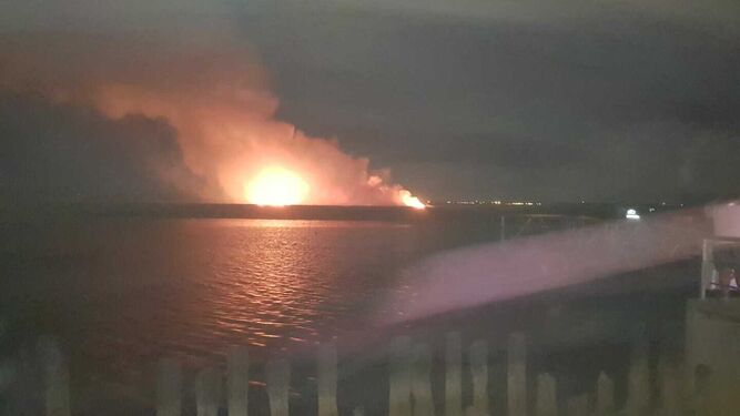 Incendio provocado por el accidente en la zona de marismas, visto desde el muelle de San Juan.