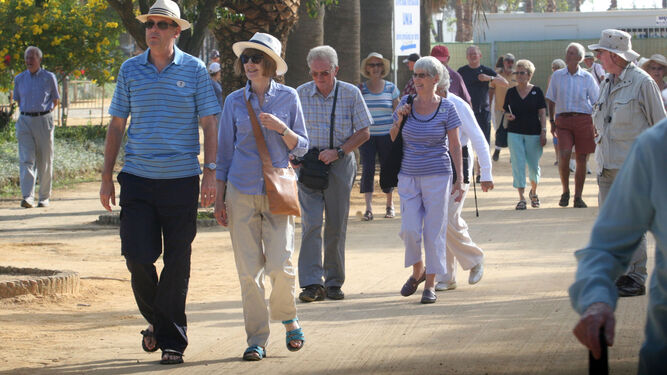 Un grupo de turistas de la tercera edad pasean por Huelva capital.