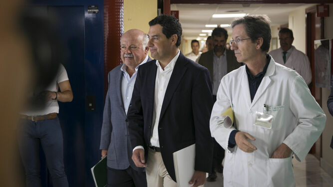 Juanma Moreno flanqueado por Jesús Aguirre y José Miguel Cisneros en su visita al Hospital Virgen del Rocío.