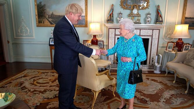 Boris Johnson da la mano a la reina Isabel II.