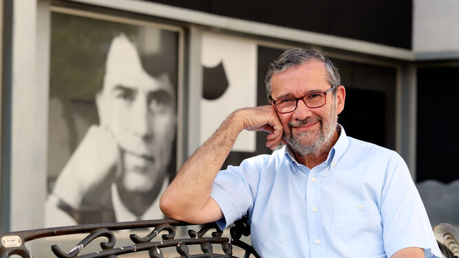 El periodista Rafael Terán posa ante la fachada del Centro de la Comunicación Jesús Hermida, donde se exhibe un gran retrato de éste.