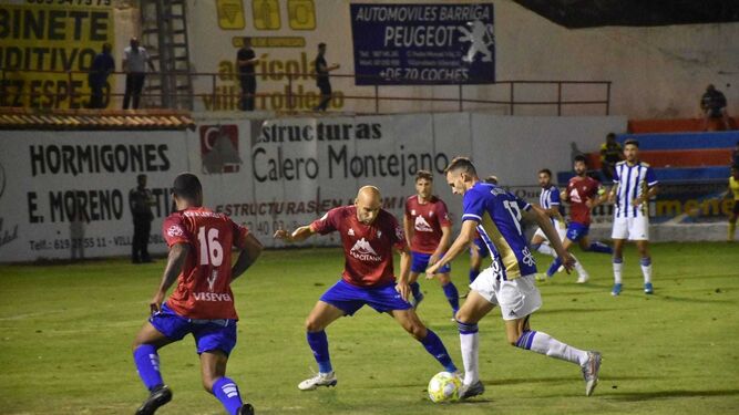 Alfonso conduce el balón acosado por dos rivales en Villarrobledo.