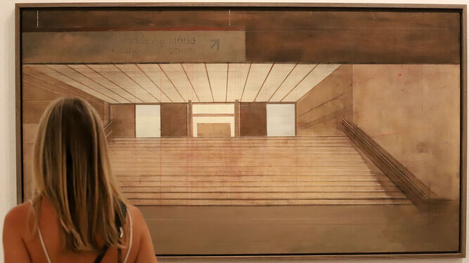 Una chica observa uno de los paisajes arquitectónicos de Daniel Bilbao expuesto en el Museo de Huelva.