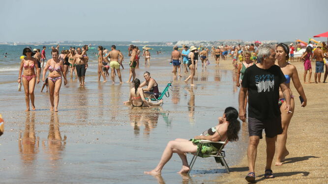 Numerosos bañistas disfrutan de un día de playa.