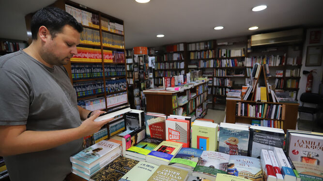 Un hombre lee en una de las librerías de Huelva.