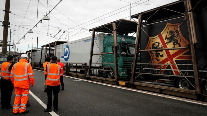 Varios operarios supervisan el paso de un convoy de camiones en las instalaciones del Eurotúnel de la localidad inglesa de Folkestone, en el condado británico de Kent