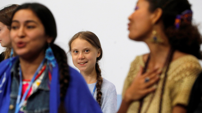 Greta Thunberg, al fondo de la imagen.