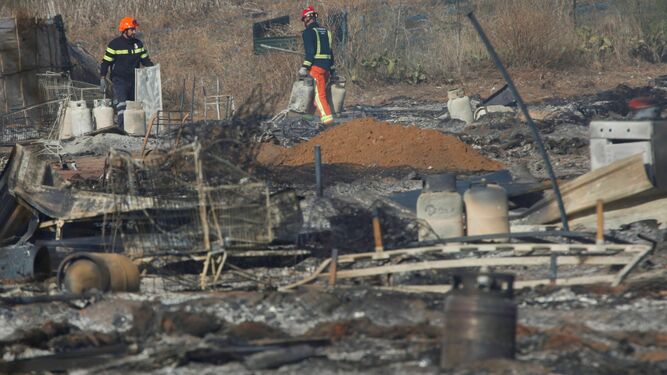 Los bomberos trabajan la mañana siguiente del gran incendio del 15 de octubre en un asentamiento de Lepe que arrasó 4 hectáreas de terreno.