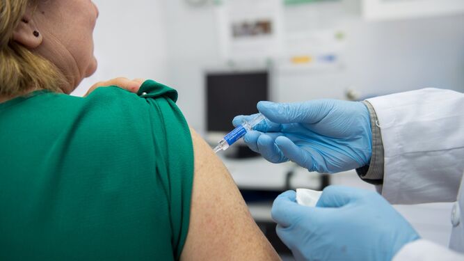 Una mujer recibe una vacuna contra la gripe.