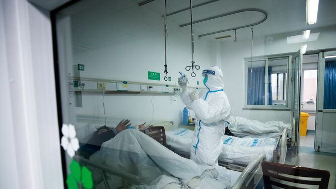 Personal médico, ataviado con trajes protectores, realiza cuidados a pacientes infectados por coronavirus en Wuhan.
