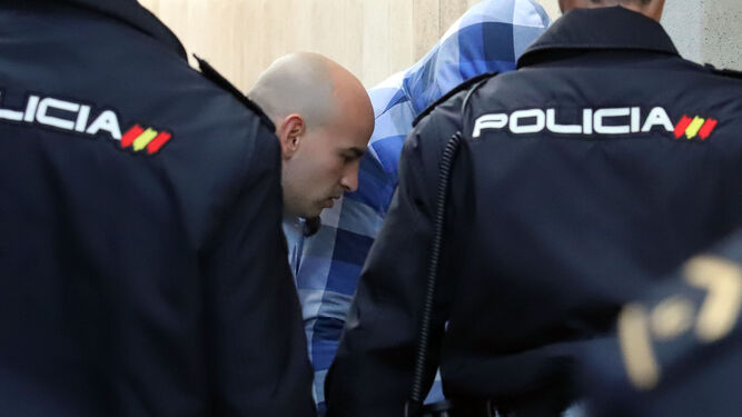 Álex Ramos y José Almansa, oculto bajo una capucha, ayer antes de la segunda sesión del juicio por el crimen de El Campillo.