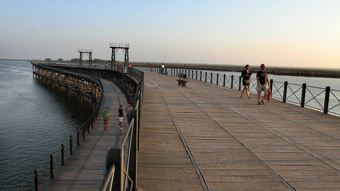 Varias personas pasean por las plataformas superiores del Muelle de la Rio Tinto Company, vestigio del pasado británico de Huelva y uno de los reclamos turísticos de la ciudad.