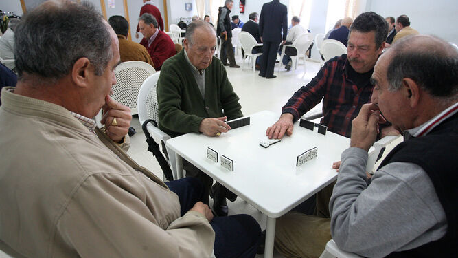Un grupo de jubilados juega al dominó en un centro para mayores.