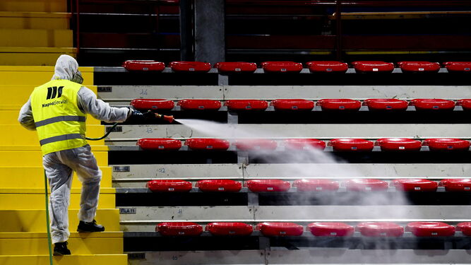 Un empleado desinfecta las gradas de un estadio italiano.