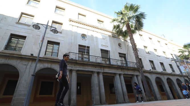 Ciudadanos pasan por delante del edificio de la Subdelegación, ubicada en la Gran Vía de Huelva.