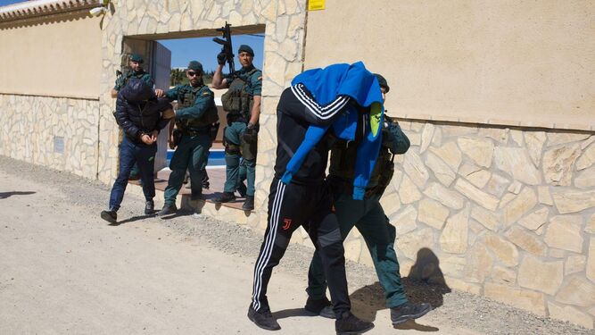 Uno de los detenidos sale escoltado por la Guardia Civil de un inmueble de Trebujena.