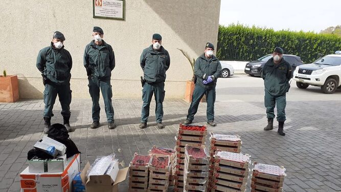 Los agentes del Deprona de Doñana posan con las fresas y el material sanitario entregado.