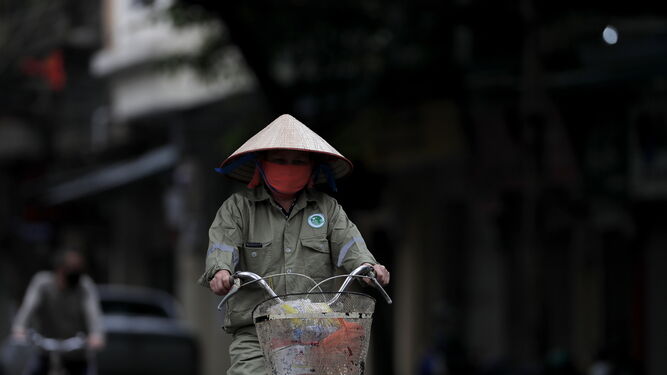 Una vietnamita se desplaza en su bicicleta
