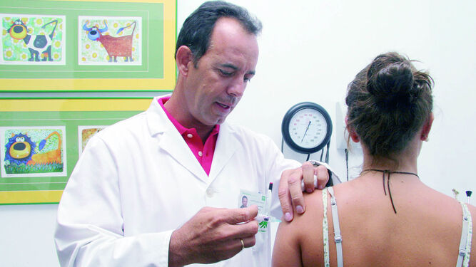 Un enfermero pone una vacuna contra el papiloma a una adolescente.