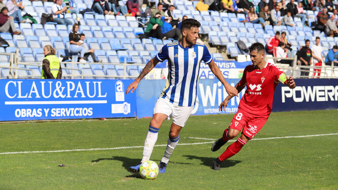 Sergio Jiménez protege el cuero ante la presión de un jugador del RealMurcia.