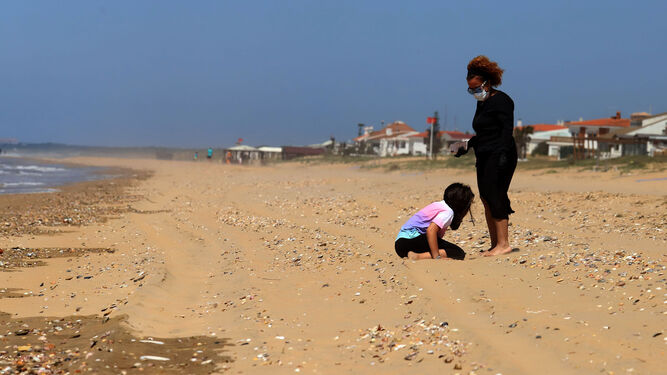 Una mujer y una niña disfrutan de la primera jornada de apertura en la playa de Punta Umbría.