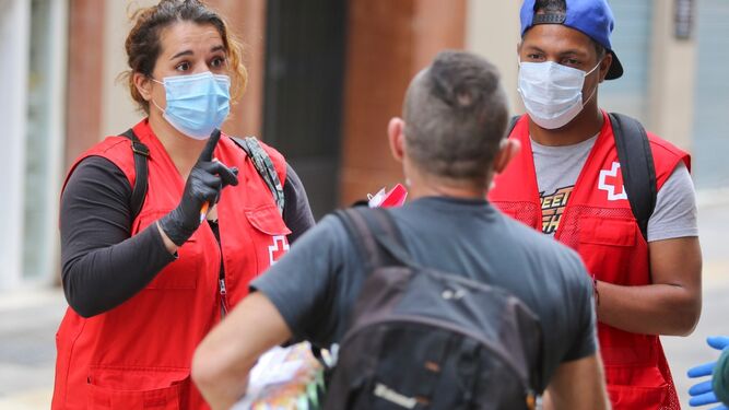 Dos voluntarios de Cruz Roja Málaga ofrecen información sobre prevención.