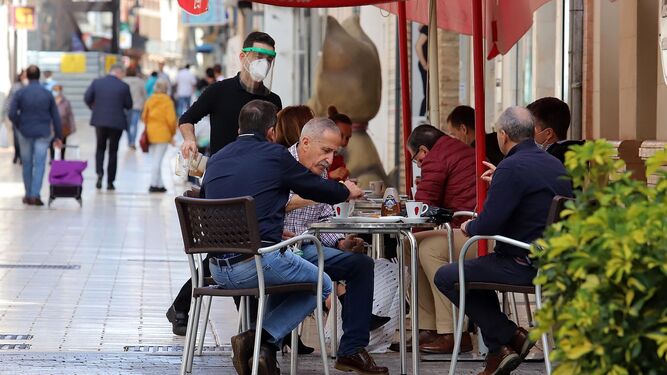 Grupos de clientes sentados en una terraza de un negocio de hostelería de Huelva.