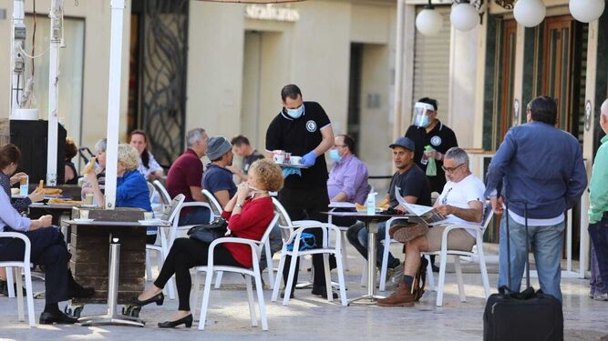 Varios camareros atienden las mesas ocupadas en un café del Centro de Málaga.