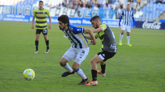 José Carlos se protege ante el acoso de un jugador del Sanluqueño.