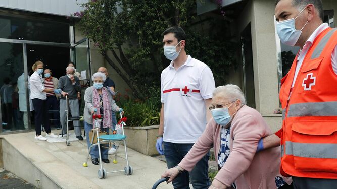Un grupo de ancianos sanos alojados en un hotel durante la pandemia son trasladados ayer por la Cruz Roja a su residencia en Santiago de Compostela.
