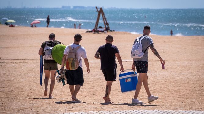 Un grupo de amigos llega a la playa de La Antilla durante la fase 3.