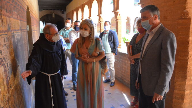 El prior del Monasterio de La Rábida muestra el deterioro de las pinturas a la consejera de Cultura, en la mañana de ayer.