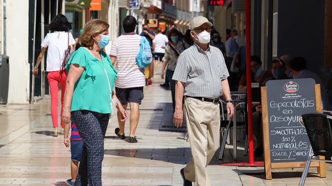 Varias personas pasean por Huelva en un día de calor.