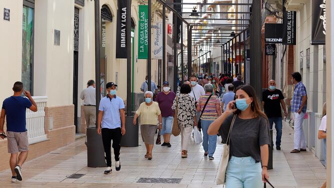 Varias personas pasean por una de las calles comerciales de Huelva.