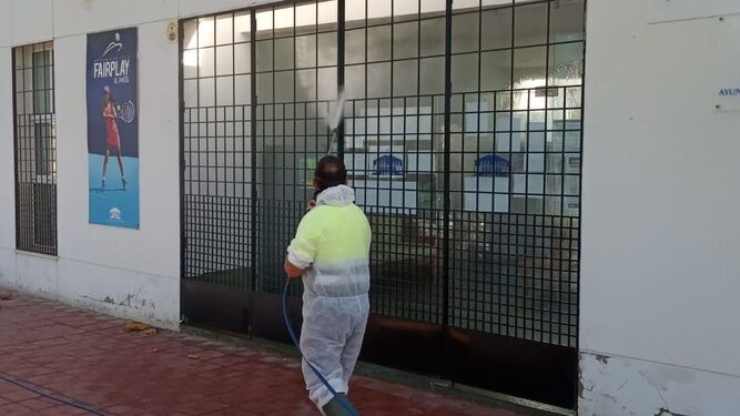 Un operario desinfecta el complejo deportivo de El Portil.