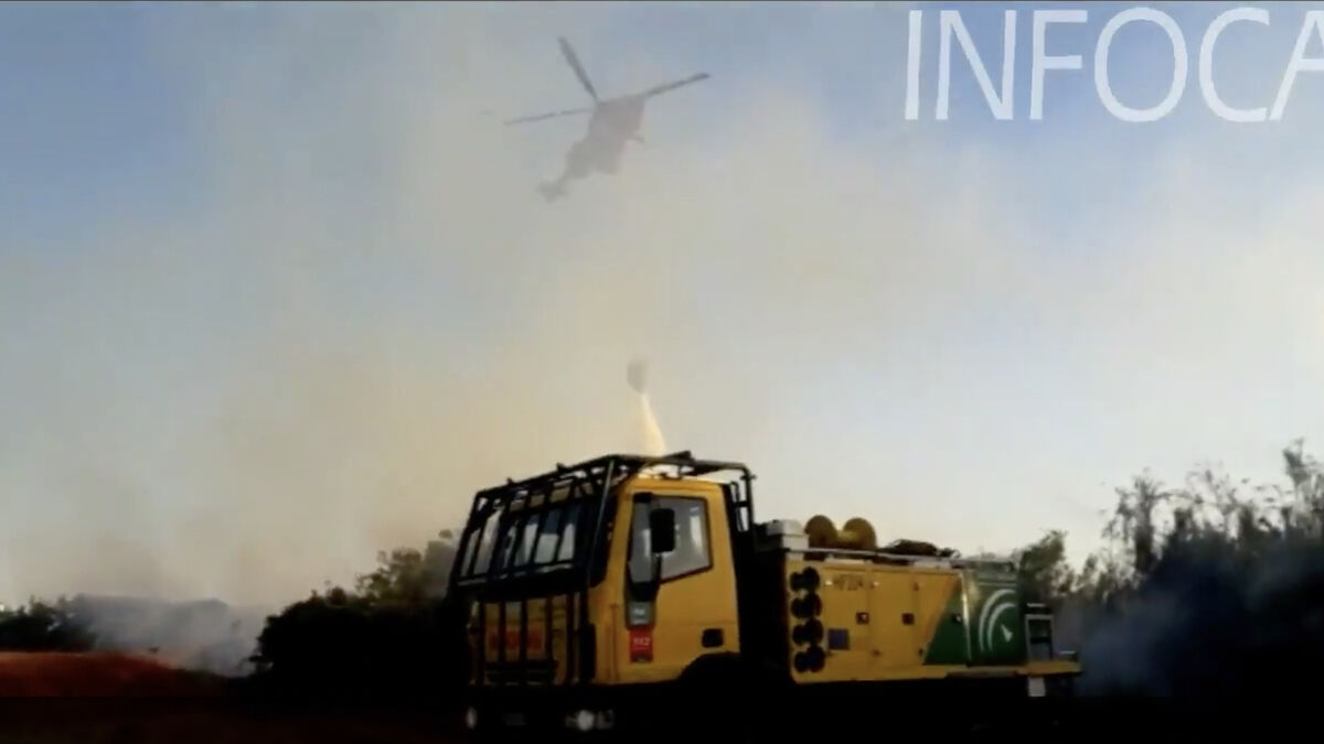 Un helicóptero del Infoca descarga agua sobre el fuego de Aljaraque.