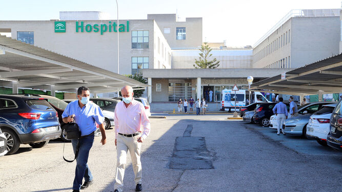 Dos personas caminan por los aparcamientos del recinto del hospital Juan Ramón Jiménez en la mañana de ayer.