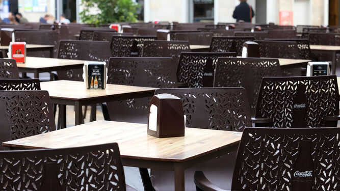 Varias mesas y sillas de una terraza de un establecimiento hostelero onubense.