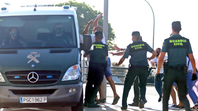 La Guardia Civil trata de contener a un hombre que se abalanza sobre el furgón, el miércoles en Ayamonte.