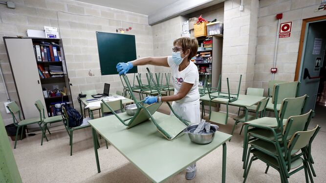 Una trabajadora procede a la limpieza de un comedor escolar.